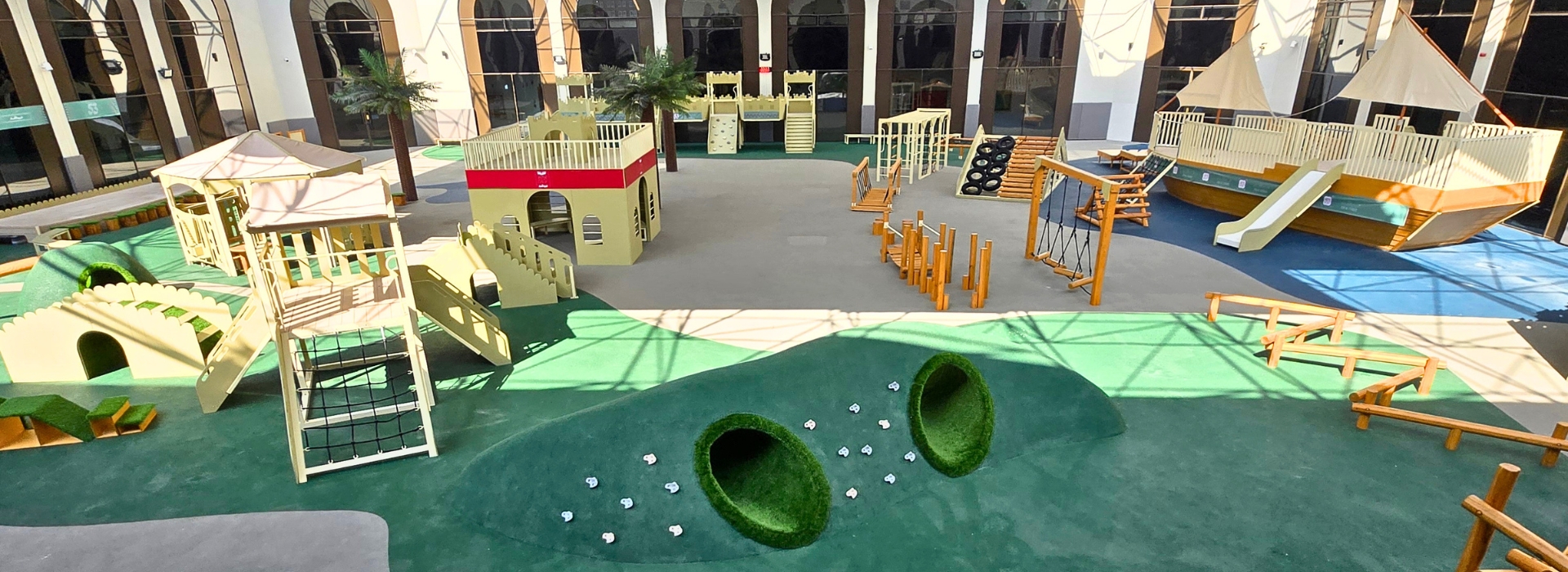 Large bespoke outdoor playground with natural timber play structures and coloured EPDM rubber safety surfacing